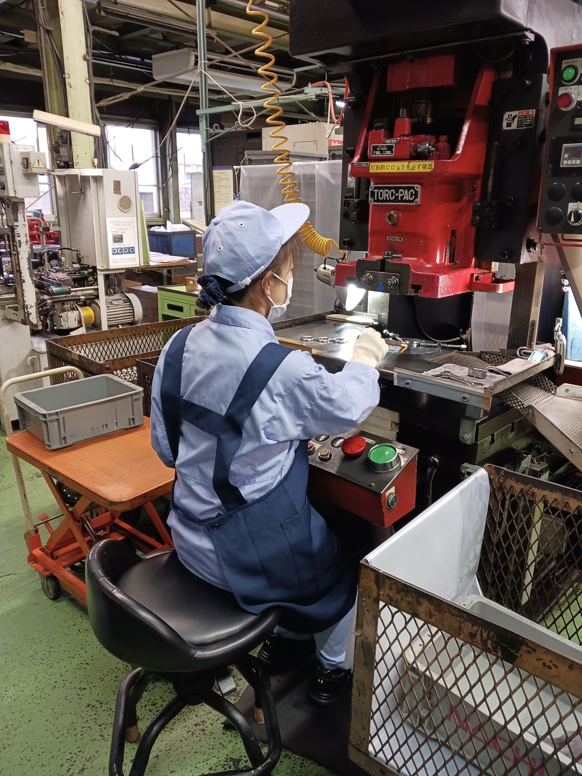 加工を終えた軸受の部品に、プレス機で刻印を打つ作業者